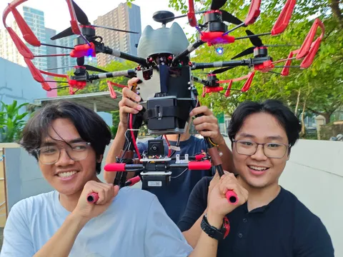 Two AeroBASE members holding the HAYABUSA drone up outdoors
