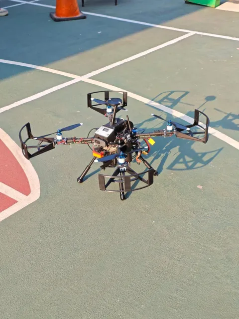 The KARASU quadcopter on an outdoor court during a flight trial