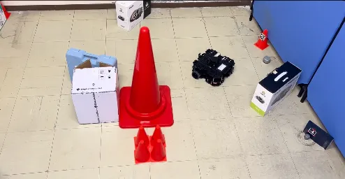 TurtleBot in the test arena at Toyohashi, surrounded by cones and boxes carrying AprilTag landmarks